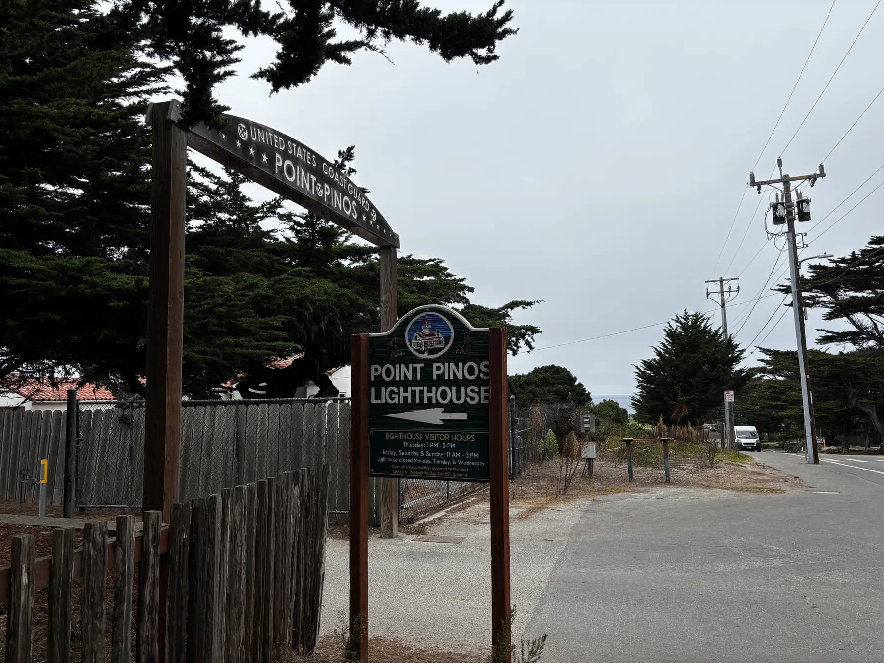 Wooden entrance sign for Point Pinos Lighthouse under cypress trees